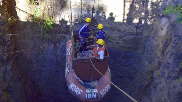 In this file photo taken on December 30, 2018, Indian Navy divers are lowered into a mine with a pulley during rescue operations to help 15 miners trapped by flooding in an illegal coal mine in Ksan village in Meghalaya's East Jaintia Hills district.(AFP)