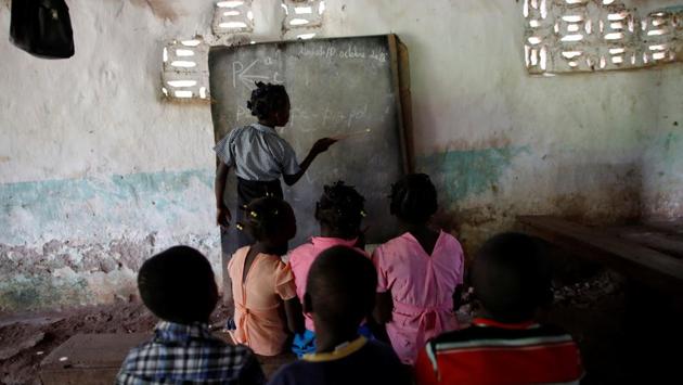 Children attend a class at the school at a Baptist church in Boucan Ferdinand. Some children, in impeccable blue uniforms, walk to a school in the town of Chapotin - a trip that takes an hour and a half over a narrow path, impassable in the rainy season. In the village are two makeshift classrooms, run by the Baptist and Catholic chapels. (Andres Martinez Casares / REUTERS) Children attend a class at the school at a Baptist church in Boucan Ferdinand. Some children, in impeccable blue uniforms, walk to a school in the town of Chapotin - a trip that takes an hour and a half over a narrow path, impassable in the rainy season. In the village are two makeshift classrooms, run by the Baptist and Catholic chapels. (Andres Martinez Casares / REUTERS)