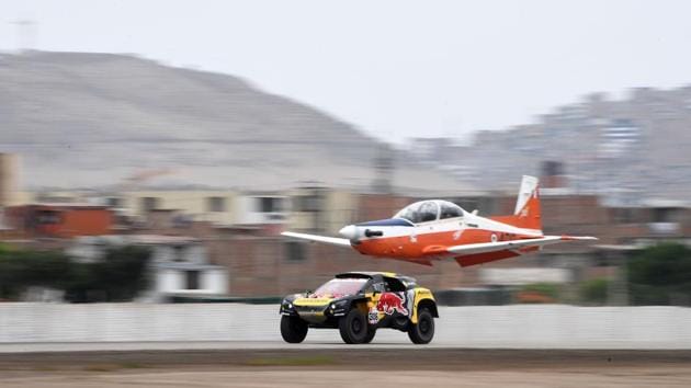 Peugeot’s French driver Sebastien Loeb and co-driver Daniel Elena power their car next to a plane before a technical check-up in Lima, on January 5, 2019. Loeb, a nine-time world rally champion who has yet to win the Dakar in three previous attempts, crashed out last year but he said he had “dodged the bullet” this time. (Franck Fife / AFP) Peugeot’s French driver Sebastien Loeb and co-driver Daniel Elena power their car next to a plane before a technical check-up in Lima, on January 5, 2019. Loeb, a nine-time world rally champion who has yet to win the Dakar in three previous attempts, crashed out last year but he said he had “dodged the bullet” this time. (Franck Fife / AFP)