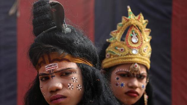 Children, dressed up as a Hindu God and Goddess, look on as they beg for alms during the Kumbh Mela. The streets of Prayagraj have become a canvas for artists with murals on various themes being painted. An area of 20 lakh sq.ft area, has been designated for street art projects under a Kumbh Mela Authority initiative called ‘Paint my city.’ (Anushree Fadnavis / REUTERS) Children, dressed up as a Hindu God and Goddess, look on as they beg for alms during the Kumbh Mela. The streets of Prayagraj have become a canvas for artists with murals on various themes being painted. An area of 20 lakh sq.ft area, has been designated for street art projects under a Kumbh Mela Authority initiative called ‘Paint my city.’ (Anushree Fadnavis / REUTERS)