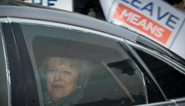 Theresa May passes a pro-Brexit demonstrator holding a 'Leave Means Leave' placard on Monday.(Bloomberg)