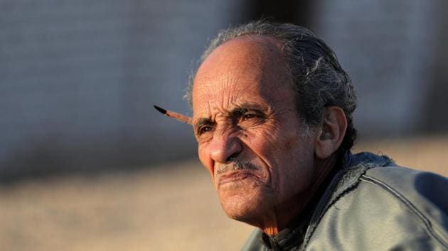 Hassan el-Shark looks into the distance after drawing a piece. Born in the village of Zawyat Sultan in 1949, the eldest son of the village butcher, Hassan el-Shark chose a vocation in art, crafting his tools from palm fibre for brushes, wrapping paper from his father’s shop as canvas and making his own paints from spices, rocks and flowers. (Mohamed Abd El Ghany / REUTERS)