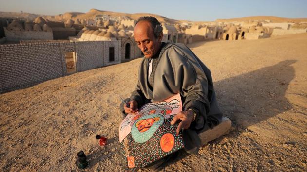 Egyptian artist Hassan el-Shark paints a piece of art with his own handcrafted colours near the ‘City of the Dead’ in Minya Governorate, Upper Egypt. El-Shark’s paintings of village life, created from the mud, grass and leaves he finds around him, are treasured in Egypt for keeping a traditional skill alive. (Mohamed Abd El Ghany / REUTERS)