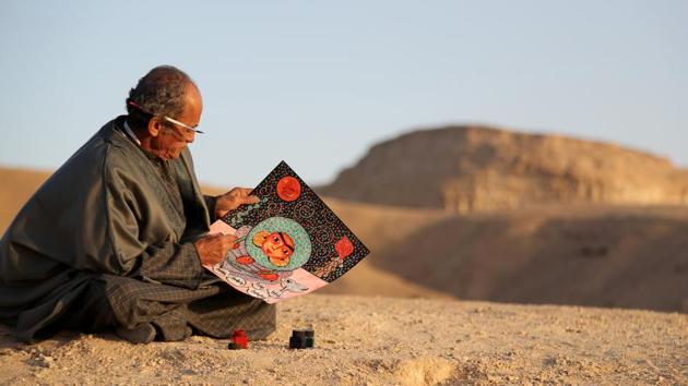 Artist Hassan el-Shark paints near the City of the Dead. Painstakingly crafting his own colours, he applies them with tiny brushes to his intricate outlines of people and forms. “It is what makes a painting last for thousands of years,” he said of his paint. (Mohamed Abd El Ghany / REUTERS)