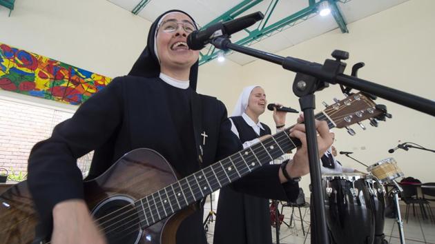 Sisters (L-R) composer, vocalist and guitar player Ivonne, 37, and vocalist Dayana, 22. With a half-dozen slick videos on YouTube, Siervas has built an international following as it communicates its message of “love, joy, hope.” Their “Trust in God” music video, which features the nuns playing on a helipad atop a Lima skyscraper, went viral on YouTube with nearly two million views. (Cris Bouroncle / AFP) Sisters (L-R) composer, vocalist and guitar player Ivonne, 37, and vocalist Dayana, 22. With a half-dozen slick videos on YouTube, Siervas has built an international following as it communicates its message of “love, joy, hope.” Their “Trust in God” music video, which features the nuns playing on a helipad atop a Lima skyscraper, went viral on YouTube with nearly two million views. (Cris Bouroncle / AFP)