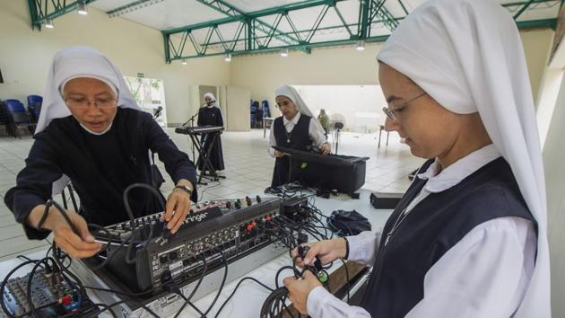 Sisters (L-R) clarinet player Jessica, 36, keyboard player and vocalist Kathleen, 37, drummer Paula, 27, and percussionist Daniela, 25, members of “Siervas” (Servants), known as the “rock nuns” prepare for their weekly rehearsal in Lima. “We’re young sisters,” said 37-year-old guitarist Sister Ivonne of the band, which includes members from Chile, Japan, Ecuador, China and Costa Rica. (Cris Bouroncle / AFP) Sisters (L-R) clarinet player Jessica, 36, keyboard player and vocalist Kathleen, 37, drummer Paula, 27, and percussionist Daniela, 25, members of “Siervas” (Servants), known as the “rock nuns” prepare for their weekly rehearsal in Lima. “We’re young sisters,” said 37-year-old guitarist Sister Ivonne of the band, which includes members from Chile, Japan, Ecuador, China and Costa Rica. (Cris Bouroncle / AFP)