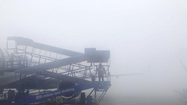 A ground staff of an airline comes down from airplane stairs on a fog covered morning at the Delhi airport in New Delhi on January 18. (AP Photo) A ground staff of an airline comes down from airplane stairs on a fog covered morning at the Delhi airport in New Delhi on January 18. (AP Photo)