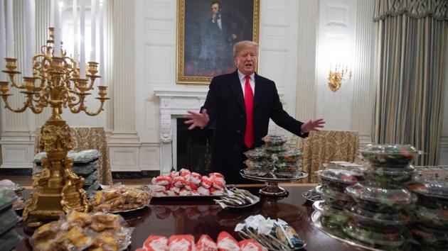 US President Donald Trump speaks alongside fast food he purchased for a ceremony honouring the 2018 College Football Playoff National Champion Clemson Tigers in the State Dining Room of the White House in Washington, DC. Trump said the White House chefs are furloughed due to the partial government shutdown. (Saul Loeb / AFP) US President Donald Trump speaks alongside fast food he purchased for a ceremony honouring the 2018 College Football Playoff National Champion Clemson Tigers in the State Dining Room of the White House in Washington, DC. Trump said the White House chefs are furloughed due to the partial government shutdown. (Saul Loeb / AFP)