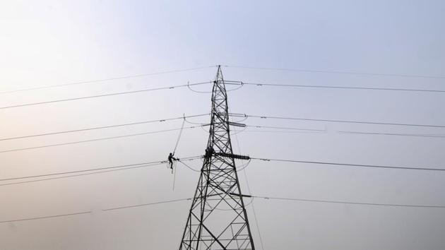 A lineman is seen on a high tension line, trying to fix the wiring adjacent to an electric tower in sector 54, in Noida, Uttar Pradesh. (Sunil Ghosh / HT Photo) A lineman is seen on a high tension line, trying to fix the wiring adjacent to an electric tower in sector 54, in Noida, Uttar Pradesh. (Sunil Ghosh / HT Photo)