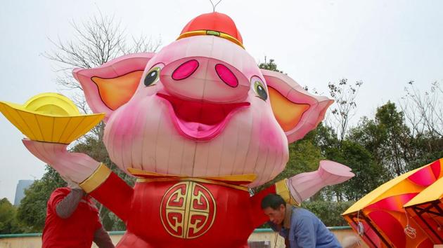 Workers set up a decoration to mark the upcoming Lunar New Year of the Pig in Nantong, China's eastern Jiangsu province (File Photo)(AFP)