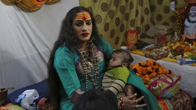 Laxmi Narayan Tripathi, chief of the ‘Kinnar Akhara’ congregation for transgender people holds a baby of her follower during Kumbh Mela in Prayagraj.(REUTERS)