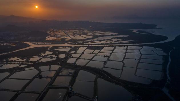 The sun sets behind a farming area in Hong Kong. Yet within easy reach of the dense urban bustle are a plethora of hiking trails and protected parkland, where it is possible to walk for hours without seeing many others. (Dale de la Rey / AFP) The sun sets behind a farming area in Hong Kong. Yet within easy reach of the dense urban bustle are a plethora of hiking trails and protected parkland, where it is possible to walk for hours without seeing many others. (Dale de la Rey / AFP)