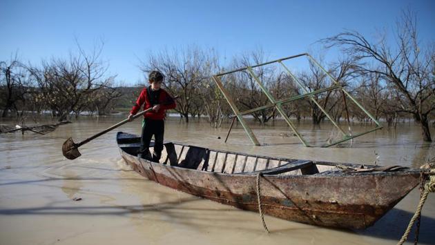 A boy uses a spade to paddle a small boat in a flooded field close to the town of Darkush. It is not the first year that he has provided his free boat service. “Most years there are spates but this year is a really big one because of the torrential rains,” Abu Ilhab said. (Aaref Watad / AFP)