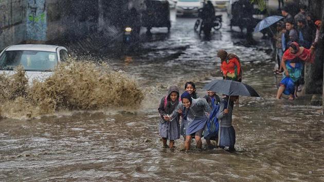 School students wade across a waterlogged road during heavy morning rain in east Delhi. Commuters were caught up in traffic jams in several places across Delhi as heavy rains and hailstorms hit the national capital and its neighbouring areas during rush hour on Tuesday morning. (Raj K Raj / HT Photo) School students wade across a waterlogged road during heavy morning rain in east Delhi. Commuters were caught up in traffic jams in several places across Delhi as heavy rains and hailstorms hit the national capital and its neighbouring areas during rush hour on Tuesday morning. (Raj K Raj / HT Photo)