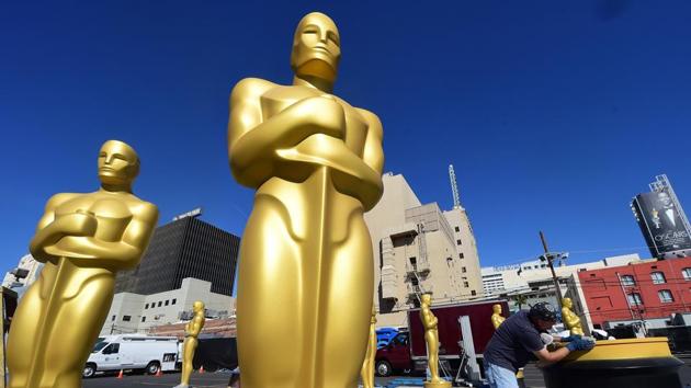 In this file photo taken on February 24, 2016 Rick Roberts works on touching up a base amid statues of the Oscar awaiting finishing up at a Hollywood back lot in Hollywood, California ahead this weekend's 88th Academy Awards.(AFP)