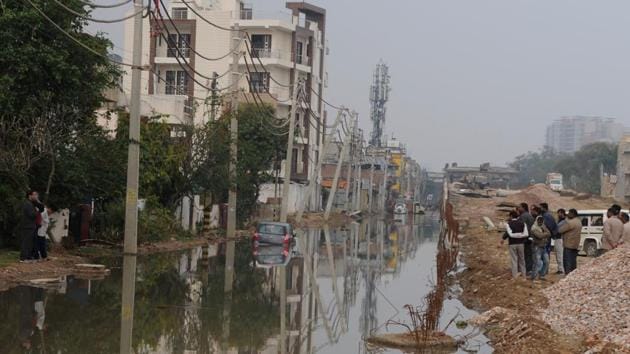 Unable to cross the service lane flooded by a mix of rainwater and sewage, GMDA and PWD officials (right) talk to residents (left) whose homes were flooded by the putrid water after over 12 hours of intermittent but heavy rain on Monday night. (Parveen Kumar / HT Photo) Unable to cross the service lane flooded by a mix of rainwater and sewage, GMDA and PWD officials (right) talk to residents (left) whose homes were flooded by the putrid water after over 12 hours of intermittent but heavy rain on Monday night. (Parveen Kumar / HT Photo)