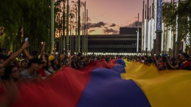 Venezuelans hold a demonstration in Medellin, Colombia in support of Juan Guaido. Analysts at the Eurasia Group consultancy noted that while international recognition of Guaido cemented his position as the main opposition leader, he had failed to win over senior elements of the military. In that light, “Maduro’s fall does not appear imminent,” the analysts wrote. (Joaquin Sarimento / AFP) Venezuelans hold a demonstration in Medellin, Colombia in support of Juan Guaido. Analysts at the Eurasia Group consultancy noted that while international recognition of Guaido cemented his position as the main opposition leader, he had failed to win over senior elements of the military. In that light, “Maduro’s fall does not appear imminent,” the analysts wrote. (Joaquin Sarimento / AFP)