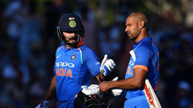 India's captain Virat Kohli (L) walks from the field with teammate Shikhar Dhawan after the sun angle halted play during the first one-day international (ODI) cricket match between New Zealand and India at McLean Park.(AFP)