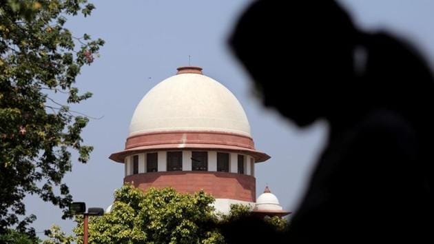 A woman checks her mobile phone inside the premises of the Supreme Court in New Delhi.(REUTERS)