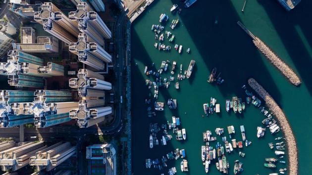 This aerial photo shows boats moored at a typhoon shelter next to residential buildings in Hong Kong. (Dale de la Rey / AFP) This aerial photo shows boats moored at a typhoon shelter next to residential buildings in Hong Kong. (Dale de la Rey / AFP)