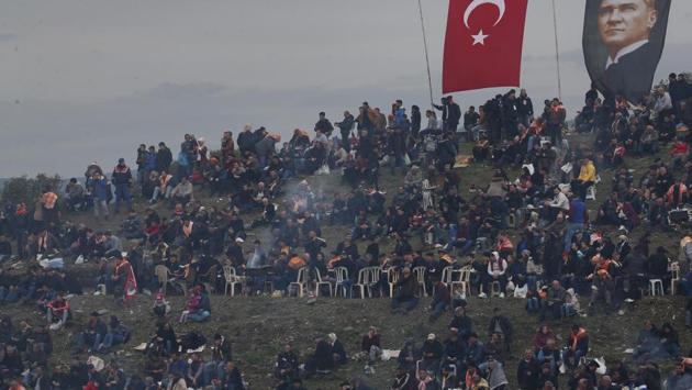 A Turkish flag and a poster of modern Turkey’s founder Mustafa Kemal Ataturk are seen on a hill full of spectators overlooking the arena. Thousands of spectators had gathered in the Aegean town to watch the event, a tradition that dates back 2,400 years. (Lefteris Pitarakis / AP) A Turkish flag and a poster of modern Turkey’s founder Mustafa Kemal Ataturk are seen on a hill full of spectators overlooking the arena. Thousands of spectators had gathered in the Aegean town to watch the event, a tradition that dates back 2,400 years. (Lefteris Pitarakis / AP)