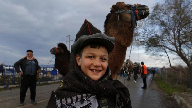 A camel handler smiles as he arrives to the festival. The first day, owners parade their champions through the town for local people to see. The camels cross the market dressed in colourful fabrics with their names embroidered on, garlands of bells and the Turkish flag. (Lefteris Pitarakis / AP) A camel handler smiles as he arrives to the festival. The first day, owners parade their champions through the town for local people to see. The camels cross the market dressed in colourful fabrics with their names embroidered on, garlands of bells and the Turkish flag. (Lefteris Pitarakis / AP)