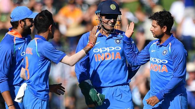 Kuldeep Yadav (R), Yuzvendra Chahal (front L) and wicketkeeper Mahendra Singh Dhoni (C) celebrate(AFP)