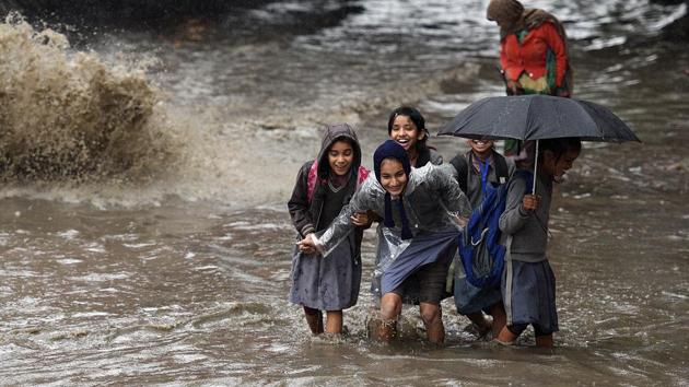 School students wade through a road waterlogged due to heavy rainfall near Ganesh Nagar in Delhi. (Raj K Raj / HT Photo) School students wade through a road waterlogged due to heavy rainfall near Ganesh Nagar in Delhi. (Raj K Raj / HT Photo)
