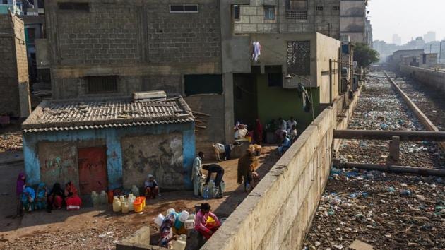 People fill water bottles and containers at a community hand pump as garbage mounds along a sewage in Karachi. (Bloomberg) People fill water bottles and containers at a community hand pump as garbage mounds along a sewage in Karachi. (Bloomberg)