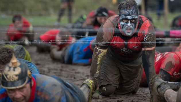 Competitors crawl under barbed wire. Chiorando knew what it was like, because she had done it once before. So why come back? “For the challenge, to see whether I can do it,” she said. (Oli Scarff / AFP) Competitors crawl under barbed wire. Chiorando knew what it was like, because she had done it once before. So why come back? “For the challenge, to see whether I can do it,” she said. (Oli Scarff / AFP)