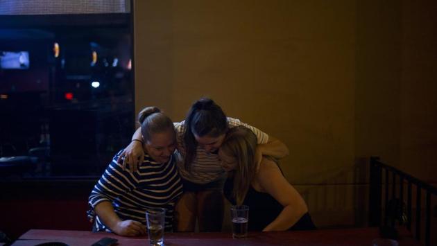 Brittaney is embraced by Abigail (C) and Dana Dukovan outside a bar. Brittaney had gone to college a couple hours away with dreams of becoming a sports analyst for ESPN. But her mother was diagnosed with breast cancer for a second time, and Landon’s addiction caused ceaseless chaos. She drove home every weekend to help, and eventually gave up on school, moved back to town and got a job as a bartender. (Jae C. Hong / AP) Brittaney is embraced by Abigail (C) and Dana Dukovan outside a bar. Brittaney had gone to college a couple hours away with dreams of becoming a sports analyst for ESPN. But her mother was diagnosed with breast cancer for a second time, and Landon’s addiction caused ceaseless chaos. She drove home every weekend to help, and eventually gave up on school, moved back to town and got a job as a bartender. (Jae C. Hong / AP)