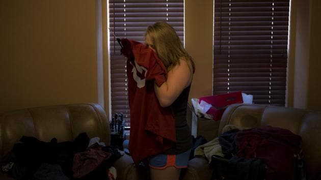 Brittaney Biggers, Landon’s sister, smells a football jersey her brother used to wear. “It still smells like him,” she said. Brittaney had moved in with her parents to save money for her own apartment and planned to stay a couple months. Then her brother died, and she picked up a second job at a bar so she could work six days a week and be so tired on the seventh she wouldn’t have to face it. (Jae C. Hong / AP) Brittaney Biggers, Landon’s sister, smells a football jersey her brother used to wear. “It still smells like him,” she said. Brittaney had moved in with her parents to save money for her own apartment and planned to stay a couple months. Then her brother died, and she picked up a second job at a bar so she could work six days a week and be so tired on the seventh she wouldn’t have to face it. (Jae C. Hong / AP)