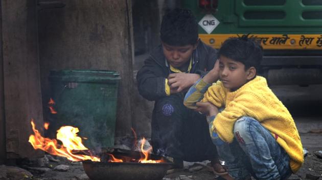 Children sit near fire to protect themselves from cold on a winter morning, at Indraprastha Extension, in New Delhi, on Sunday, January 27, 2019. (Sushil Kumar/HT Photo) Children sit near fire to protect themselves from cold on a winter morning, at Indraprastha Extension, in New Delhi, on Sunday, January 27, 2019. (Sushil Kumar/HT Photo)