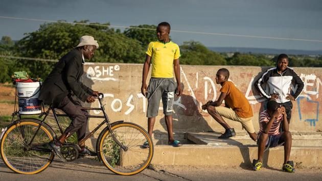 As the morning progresses, traffic picks up and the small crowd clears off the road to allow cars, trucks and buses to hurtle past on their way to and from Bulawayo, Zimbabwe’s second city. (Zinyange Auntony / AFP) As the morning progresses, traffic picks up and the small crowd clears off the road to allow cars, trucks and buses to hurtle past on their way to and from Bulawayo, Zimbabwe’s second city. (Zinyange Auntony / AFP)