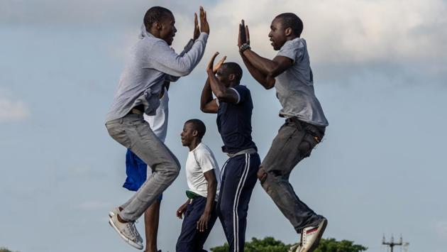 The session ends with a coordinated exercise when about eight pairs run towards each other from either side of the road. They jump in the air 10 times, clapping their partner’s hand each time in a final burst of energy. (Zinyange Auntony / AFP) The session ends with a coordinated exercise when about eight pairs run towards each other from either side of the road. They jump in the air 10 times, clapping their partner’s hand each time in a final burst of energy. (Zinyange Auntony / AFP)