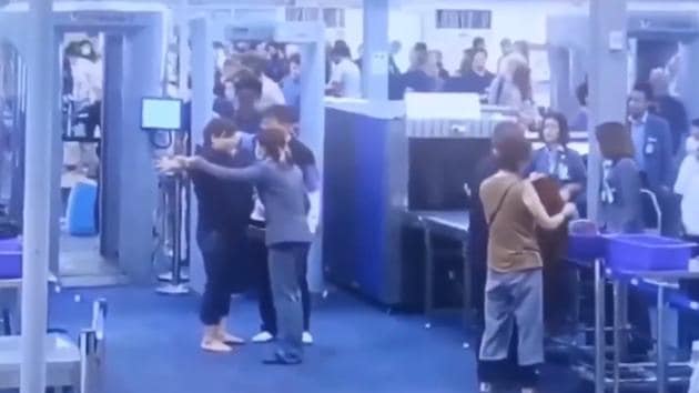The woman first appeared to refuse the check but eventually stood with her arms raised for the security check.(Screengrab)