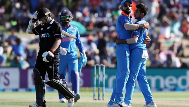 New Zealand's Tom Latham (L) is dismissed as India's Virat Kohli (C) and Yuzvendra Chahal (R) embrace during the third one day international cricket match between New Zealand and India at Bay Oval(AFP)