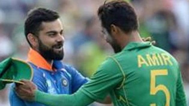 Mohammad Amir, left, looks on as India's Shikhar Dhawan, right, and captain Rohit Sharma run between the wickets.(Getty Images)