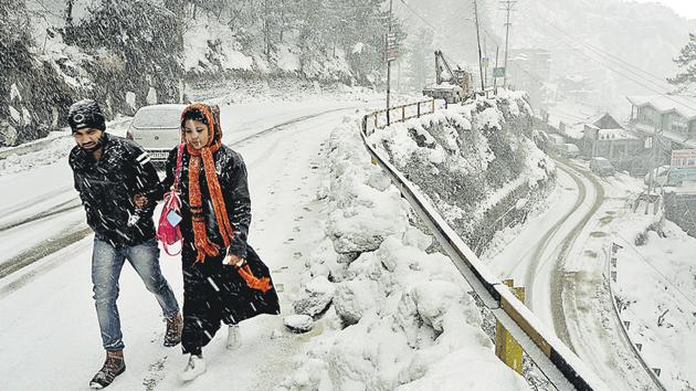 A couple walking during snowfall on the Dhalli-Kufri highway in Shimla district on Monday, January 28, 2019.(Deepak Sansta / HT Photo)