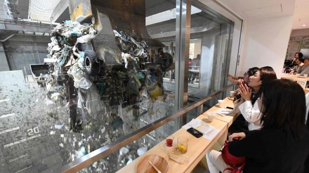 Customers watch an enormous crane pick up rubbish for incineration at a combustible waste pit while having a drink and snack in Tokyo, Japan. The pop-up bar -- called Gomi (trash) Pit -- is the initiative of local officials who are trying to promote their state-of-the-art facility and prod local residents to think about the waste they produce. (Toshifumi Kitamura / AFP) Customers watch an enormous crane pick up rubbish for incineration at a combustible waste pit while having a drink and snack in Tokyo, Japan. The pop-up bar -- called Gomi (trash) Pit -- is the initiative of local officials who are trying to promote their state-of-the-art facility and prod local residents to think about the waste they produce. (Toshifumi Kitamura / AFP)
