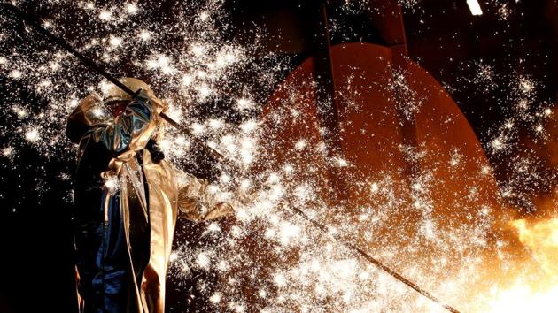 A steel worker of Germany’s industrial conglomerate ThyssenKrupp AG, stands amidst emitting sparks of raw iron from a blast furnace at Germany’s largest steel factory in Duisburg. (Wolfgang Rattay / REUTERS)