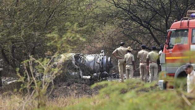 Police personnel stand near the wreckage of the Mirage-2000 fighter aircraft after it crash landed in Bengaluru on Friday. “Today morning a Mirage 2000 trainer aircraft on an acceptance sortie after upgrade by HAL crashed at HAL airport, Bengaluru. Both occupants sustained fatal injuries. Further details are awaited. Investigation into the cause of accident is being ordered.” the IAF said in a statement. (Shailendra Bhojak / PTI)