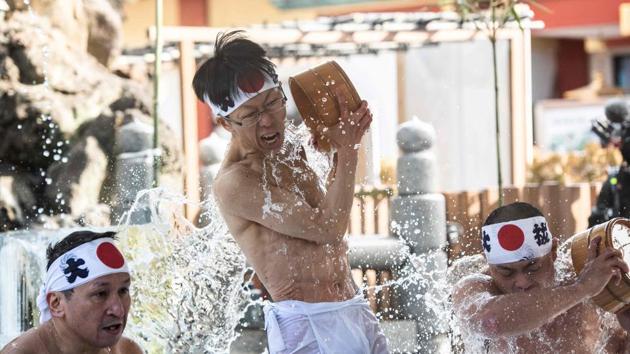 Shinto followers pour cold water over themselves to purify body and soul as part of an endurance ritual at Kanda Shrine, known as “Kanda Myojin”, in Tokyo, Japan. (Martin Bureau / AFP)