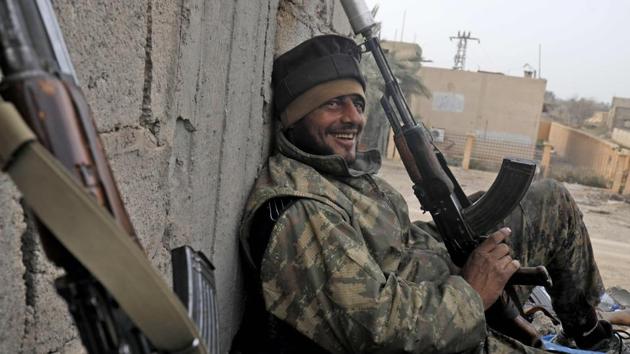 A member of Syria’s Arab Shaytat tribe who has joined a Kurdish-led alliance fighting the Islamic State group in northern Syria, rests during his break in the Syrian village of Baghouz. (Delil Souleiman / AFP)