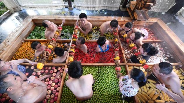 People enjoy a barbecue as they bath in a hotpot-shaped hot spring filled with fruits and vegetables, at hotel in Hangzhou, Zhejiang province, China. (REUTERS)