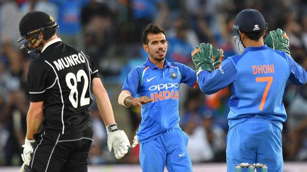 New Zealand's Colin Munro (L) walks from the field after being caught with LBW as India's Yuzvendra Chahal (C celebrates with team mate keeper MS Dhoni.(AFP)