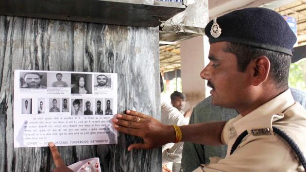 A file photo of a security personnel pasting posters at a railway station of eight SIMI members who had escaped from Central Jail killing a security guard in Bhopal in 2016.(PTI file photo) A file photo of a security personnel pasting posters at a railway station of eight SIMI members who had escaped from Central Jail killing a security guard in Bhopal in 2016.(PTI file photo)