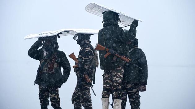 Indian paramilitary personnel stand guard on the shore of the Dal lake during heavy snowfall in Srinagar, Jammu and Kashmir. (Tauseef Mustafa / AFP)