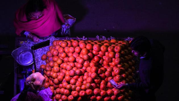 A woman purchases oranges from a roadside vendor in New Delhi. (Sajjad Hussain / AFP)