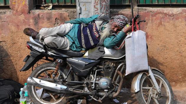 A man sleeps on a motorbike in the old quarters of Delhi. (Sajjad Hussaiin / AFP)
